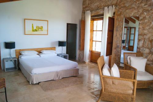 a bedroom with a bed and chairs in a room at Agroturismo Ses Cases de Fetget in Son Servera