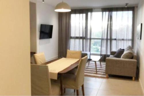a living room with a dining room table and a couch at Tres Arroyos Plaza San Martín in Tres Arroyos