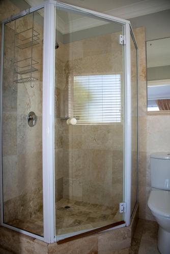 a shower with a glass door in a bathroom at WATERFRONT 2 BR Home with mooring at Knysna Quays - life on the water in Knysna