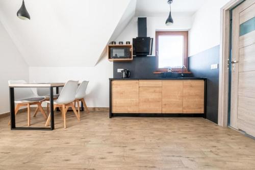 een keuken en eetkamer met een tafel en stoelen bij Tatra Apartments z zewnętrznym jacuzzi in Biały Dunajec