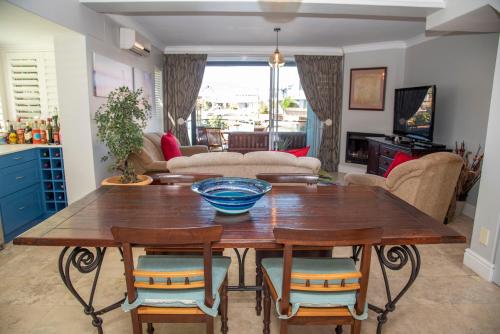 a living room with a wooden table and chairs at WATERFRONT 2 Bed Home with mooring at Knysna Quays in Knysna