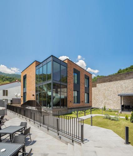 a building with glass windows and tables on a patio at Aurora Luxe in Dilijan