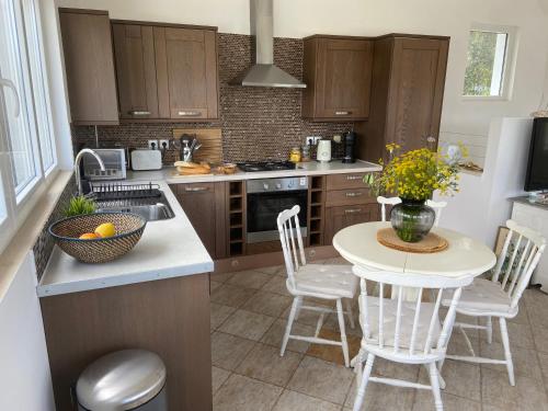 a kitchen with a table and chairs and a sink at Villa by the Lake in Karoubatika near Agios Ioannis in Agios Ioannis