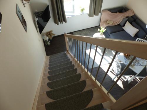 a staircase in a living room with a blue couch at B-Haus Ueckermünde in Ueckermünde