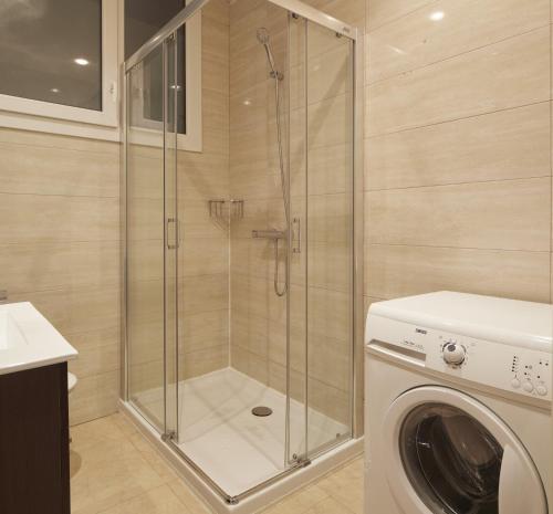a shower in a bathroom with a washing machine at Aiztondo - Basque Stay in San Sebastián