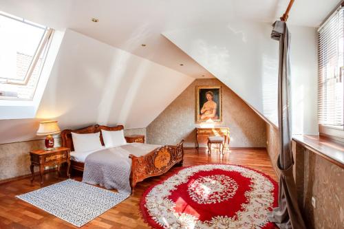 Zimmer im Dachgeschoss mit einem Bett und einem roten Teppich in der Unterkunft Classic Old Town Apartment next to the Gates of Dawn in Vilnius