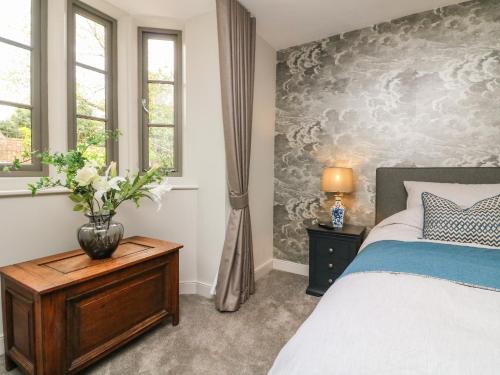 a bedroom with a bed and a vase on a table at Court Lodge in Taunton