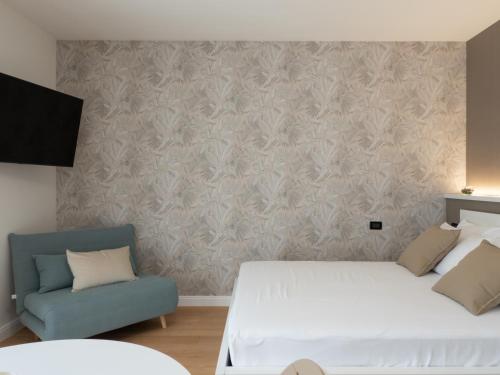 a bedroom with a white bed and a blue couch at Franci Loft in Pescara