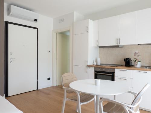 a white kitchen with a white table and chairs at Franci Loft in Pescara