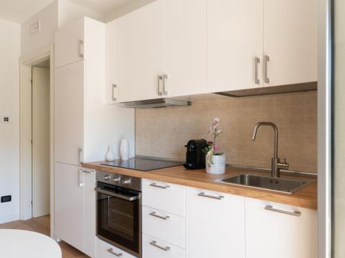 a kitchen with white cabinets and a sink at Franci Loft in Pescara