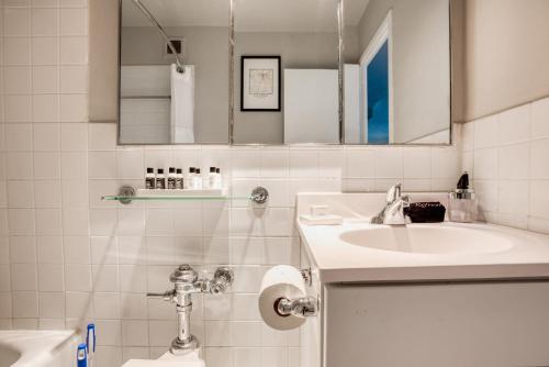 a bathroom with a sink and a toilet and a mirror at CozySuites 800 Tower 1BR w sky pool, gym! 16 in Louisville