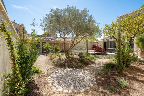 un jardin avec des arbres et un chemin en pierre dans l'établissement La Fontaine aux Fées, à Lagnes
