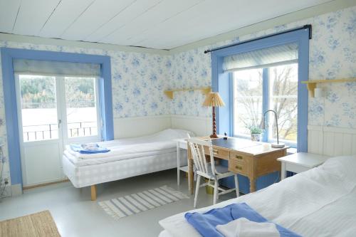 Schlafzimmer mit einem Schreibtisch, einem Bett und einem Tisch in der Unterkunft Sundets Gård - Bed & Breakfast in Kopparberg