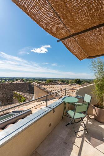 d'une terrasse avec une table et une chaise sur un balcon. dans l'établissement La Fontaine aux Fées, à Lagnes
