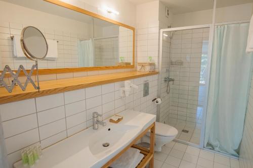 a bathroom with a sink and a toilet and a mirror at Lijo in Gargždai