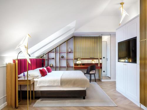 a bedroom with a bed and a desk and a television at Golden Queen Deluxe Jacuzzi Apartments - Old Town in Kraków