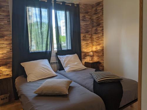 - 2 lits avec oreillers dans une chambre avec fenêtre dans l'établissement Chez Lou appartement proche du lac moderne, à Annecy