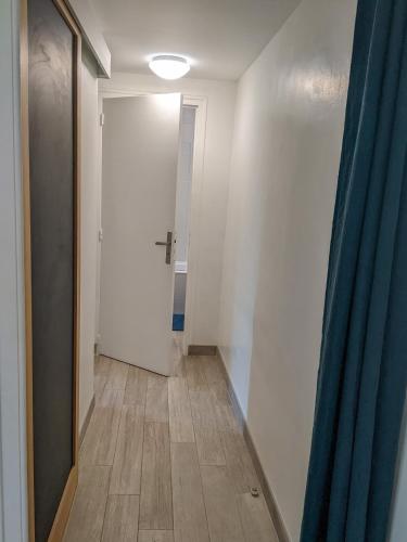 un couloir avec une porte et un rideau bleu dans l'établissement Chez Lou appartement proche du lac moderne, à Annecy
