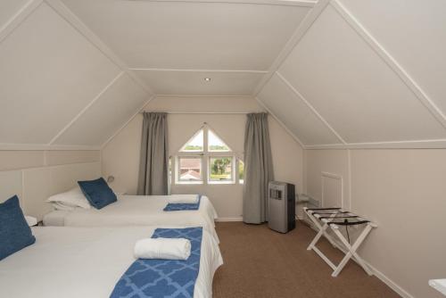1 dormitorio con 2 camas y ventana en Millard Crescent Guest House en Puerto Elizabeth
