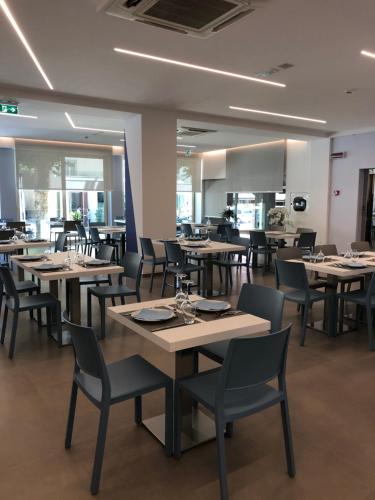 a dining room with tables and chairs in a restaurant at Hotel Muccioli in Misano Adriatico