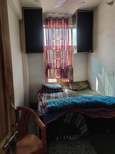 Habitación pequeña con cama y ventana en Hotel EPS, en Ghaziabad