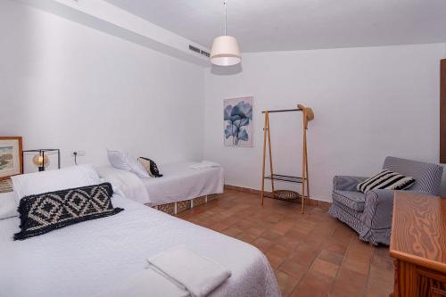 Cette chambre comprend 2 lits et une chaise. dans l'établissement Cal Papa, à Cala Sant Vicenç