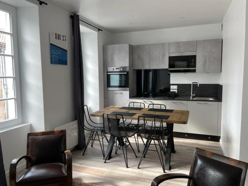 une cuisine avec une table et des chaises dans une pièce dans l'établissement Le St Louis 5 Appartement 2 pièces, à La Rochelle