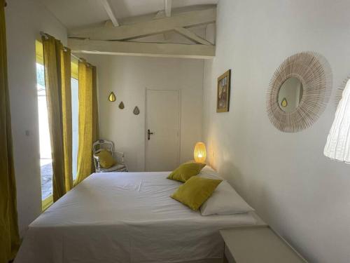 une chambre avec un lit et un miroir au mur dans l'établissement Le clos de la tour cassis piscine chauffée, à Cassis