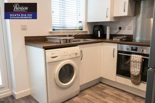 a kitchen with a washing machine and a sink at Lovely Brand New 2 Bed House with Driveway Parking in Longford