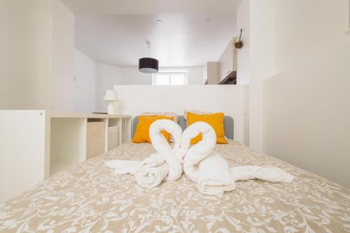 - une chambre avec 2 serviettes de cygne sur un lit dans l'établissement LE CHEZY, à Rennes