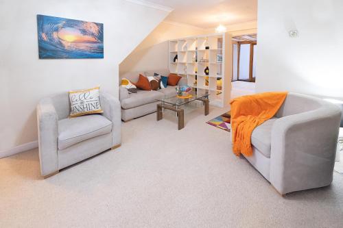 sala de estar con 2 sillas y sofá en Charming family house in High Wycombe en Buckinghamshire