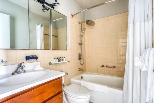 a bathroom with a tub and a toilet and a sink at Spacious 2BR 2BA CozySuites with gym 30 in Louisville