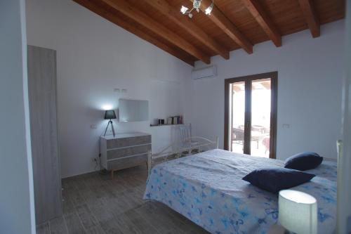 a white bedroom with a bed and a window at No Zu Filì in Villaggio Mosè