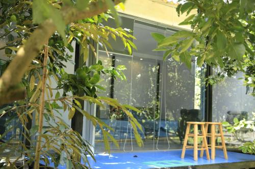 a pair of chairs sitting on a table in front of a house at Homestay Vườn Trái Cây Nhiệt Đới VÔ ƯU GARDEN in Bao Loc