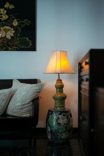 a lamp sitting on a table next to a bed at Amanaki Thao Dien in Ho Chi Minh City