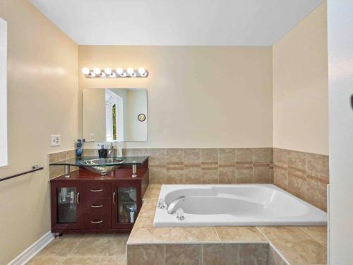 baño con bañera grande y lavamanos en Spacious Family Home Close To Downtown with King Bed num1 en Ottawa