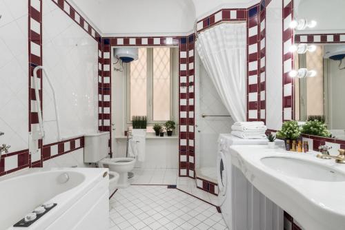 a bathroom with two sinks and a tub and a toilet at Appartamento Principe Amedeo in Rome