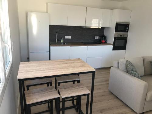 - une cuisine avec une table et un canapé dans une chambre dans l'établissement Appartement en bord de plage serviettes non incluses, à Frontignan