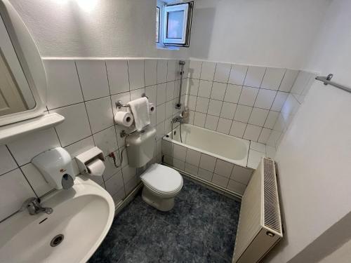 a bathroom with a sink and a toilet and a tub at Grey House in Braşov