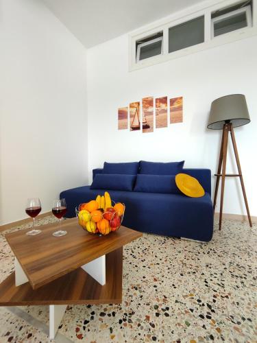 a living room with a blue couch and a table at Oasis Apartments in Perissa