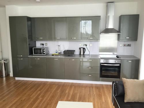 a kitchen with stainless steel cabinets and a microwave at Castle Quarter Apartment with Free on site Parking in Bedford