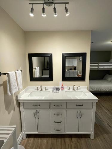 a bathroom with a white sink and two mirrors at The Harbour House in Charlottetown