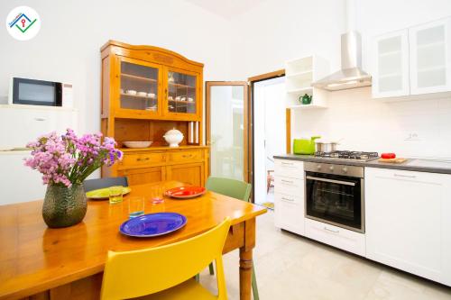 une cuisine avec une table en bois et des chaises jaunes dans l'établissement A Casa Di Rosa, à Migliarino
