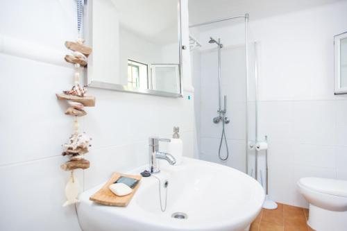 a white bathroom with a sink and a toilet at Voramar Ham in Playa de Muro