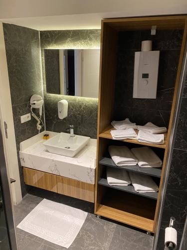 a bathroom with a sink and a mirror at BLACKLAKE OTEL in Borçka