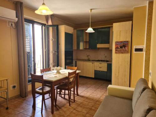 a kitchen and dining room with a table and chairs at Casa in Centro in SantʼAntìoco
