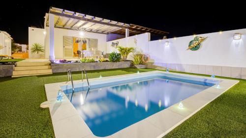 a swimming pool in the yard of a house at night at Villa Amatista Salinas Golf & Beach in Caleta De Fuste