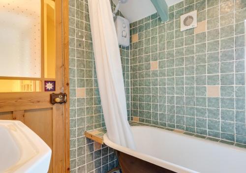a bathroom with a bath tub and a sink at Crown Mine Cottage in St. Just