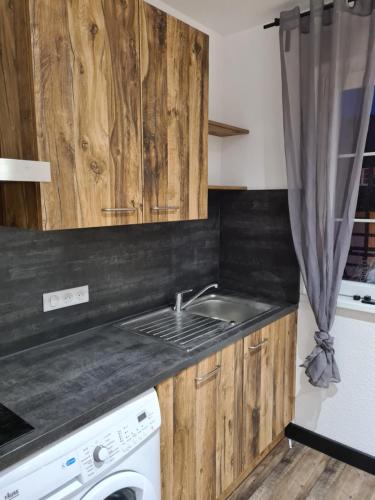 eine Küche mit Spüle und Waschmaschine in der Unterkunft Gîte Au Coin du Chêne in Lembach