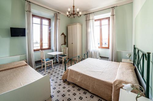 a bedroom with two beds and a table and chairs at Liberty GuestHouse in Lucca